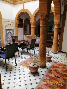 a room with tables and chairs in a building at Riad Zawia in Essaouira