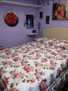 a bed covered in flowers in a bedroom at Le stanze di Linda in Coppito