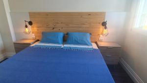 a bedroom with a blue bed with two blue pillows at BRUMA HOSTEL in Ponta Delgada