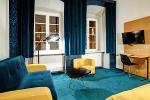 a hotel room with a couch and chairs and a desk at TCZ Woźna in Poznań