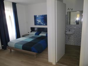 una camera con letto, lavandino e specchio di Agriturismo G.GARTROZ a Gorizia