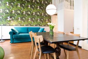 a dining room with a table and a blue couch at Central Monserrato House with Balcony in Rome