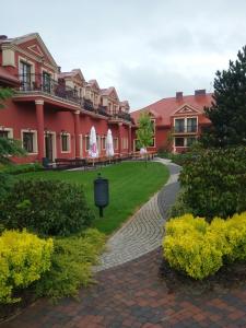 a walkway in front of a large red building at Hotel Milord in Pułtusk