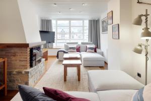 een woonkamer met witte meubels en een open haard bij Comets by FeelFree Rentals in Vielha