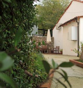 a patio with a table and a closed umbrella at La casa di Julie in Ronchi dei Legionari