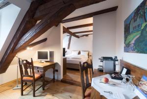 a room with a desk and a bedroom with a bed at Hotel Ochsen Post in Tiefenbronn