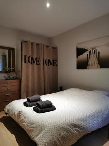 a bedroom with a bed with two towels on it at La maisonnette au centre ville in Lens