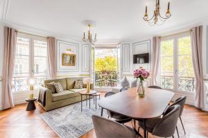 a living room with a table and a couch at Luxury 2 Bedroom With Balcony - Louvre & Notre Dame in Paris