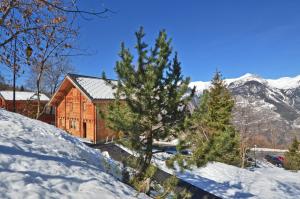 una casa en la nieve con árboles y montañas en Chalet Phoenix, en Montalbert