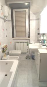 a white bathroom with a sink and a toilet at Le stanze di Linda in Coppito