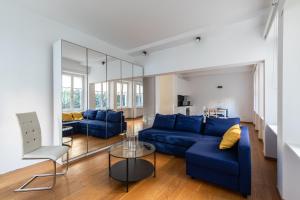un salon avec un canapé bleu et une table en verre dans l'établissement Tigli Apartment by Quokka 360 - bright lakeside flat, à Lugano