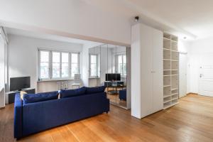 a living room with a blue couch and a mirror at Tigli Apartment by Quokka 360 - bright lakeside flat in Lugano