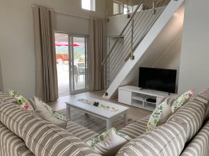 sala de estar con sofá y TV en The Suites at Waterryk Eco Guest Farm, en Stilbaai