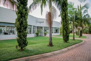 un bâtiment avec des palmiers en face de celui-ci dans l'établissement Twangale Resort & Spa, à Lusaka