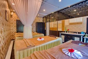 a room with three beds and a kitchen in it at Fivitel Hoi An Hotel in Hoi An