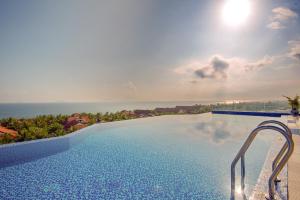a swimming pool with a view of the ocean at Fivitel Hoi An Hotel in Hoi An