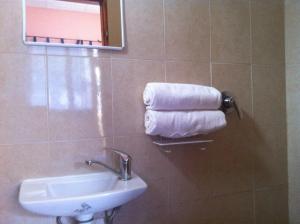 a bathroom with a sink and towels on a wall at Hotel 28 in Tel Aviv