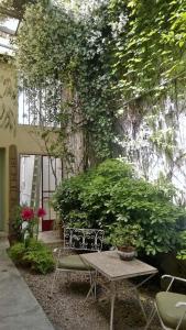 a garden area with a table, chairs, and plants at Palermo Viejo Bed & Breakfast in Buenos Aires