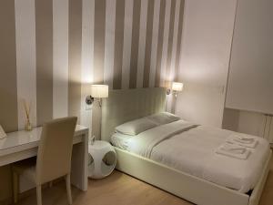 1 dormitorio con cama, escritorio, mesa y silla en B&B Sallustio Rooms, en Siena