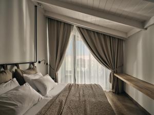 a bedroom with a bed with a large window at Contessina Hotel in Tsilivi