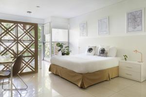 a white bedroom with a large bed and a desk at Feel Buenos Aires in Buenos Aires