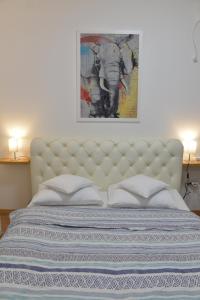 ein Schlafzimmer mit einem Bett mit einem Elefantenbild an der Wand in der Unterkunft Pupin Palata business apartman B5 in Novi Sad