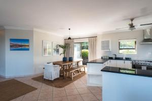 バリートにあるShangri-La 6 Bedroom Ballito Beachfront KBW1のテーブルとダイニングルームのあるキッチン
