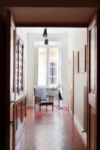 een hal met een tafel, een stoel en een raam bij MyNavona in Rome
