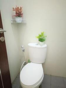 a bathroom with a toilet with two plants on it at Alysahouse - 2 Bedrooms, Dekat JTP3 in Batu +14 photos