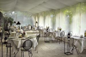 une salle avec tables et chaises et nappes blanches dans l'établissement Le Mas de Peint - Teritoria, à Le Sambuc