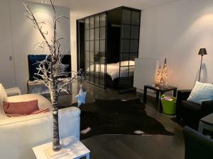 een woonkamer met een boom en een slaapkamer bij Exclusief appartement in hartje Zoute, zonnig terras met zeezicht in Knokke-Heist