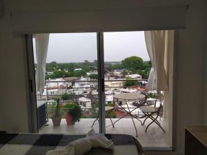 a bedroom with a view of a balcony with a table and chairs at Departamento Parque Alem in Rosario