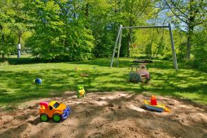 einen Spielplatz mit Spielzeug im Sand in einem Park in der Unterkunft KNAUS Campingpark Bad Kissingen in Bad Kissingen