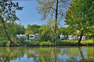 KNAUS Campingpark Bad Kissingen في باد كيسينغن: مجموعة من الحافلات المحاذية للبحيرة