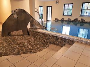 ein Schwimmbad mit einer Delfinstatue in einem Gebäude in der Unterkunft Ferienwohnung Allgäublick Regina in Bad Hindelang