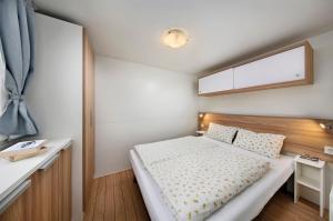 een kleine slaapkamer met een bed en een bureau bij KNAUS Campingpark Bad Kissingen in Bad Kissingen