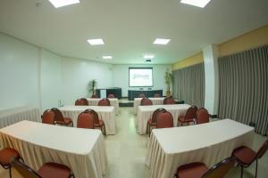 a conference room with tables and chairs and a screen at Sofisticatto Park Hotel in Formosa
