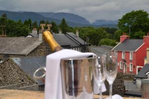 a bottle of wine sitting on a table with wine glasses at Fairhill House Hotel in Clonbur