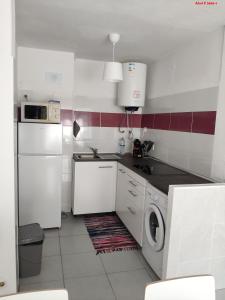 kuchnia z białymi urządzeniami oraz pralką i suszarką w obiekcie Alsol C 5365-1 w mieście Quarteira