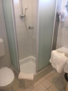 ein Bad mit einer Dusche, einem WC und einem Waschbecken in der Unterkunft Hotel Arnold in Tata
