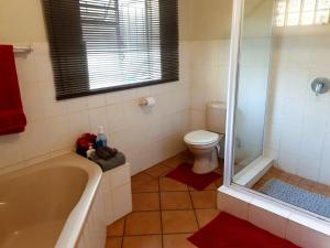 a bathroom with a tub and a toilet at SnL 38 Hoep Hoep in Malelane