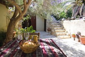 uma mesa com um cesto de copos de vinho e uma árvore em Avli-the courtyard em Nicósia