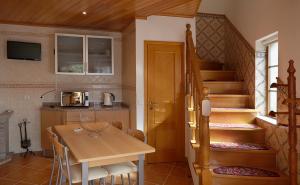 uma cozinha com uma mesa e uma escada num quarto em Abrigo da Montanha - Alojamento Familiar em Sabugueiro