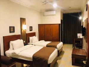 a hotel room with two beds and a television at Hotel One Jinnah, Islamabad in Islamabad