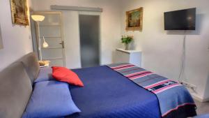 a bedroom with a bed with a blue blanket at Villa Laila in Lodi +2 photos
