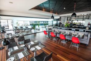 a restaurant with red chairs and tables and a bar at Pestana Cidadela Cascais - Pousada & Art District in Cascais