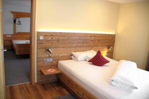 a bedroom with a bed with a wooden headboard at Land-gut-Hotel Höhengasthof Adler in Lauterbach