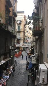 an alley with people walking down a street with buildings at 4STANZE in Naples