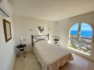 Un dormitorio con una cama y una ventana grande. en Duplex Vistamar X2154, en Benitachell 51 fotos más