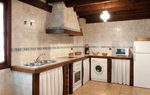 eine Küche mit einer Spüle und einer Waschmaschine in der Unterkunft Casa Rural La Panera in Cillamayor